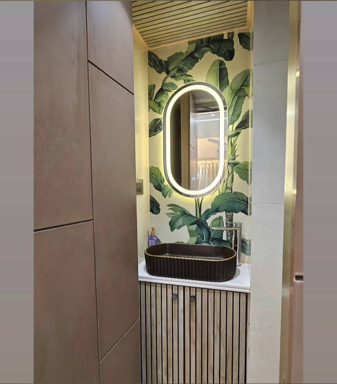 Tropical themed bathroom with LED backlit mirror